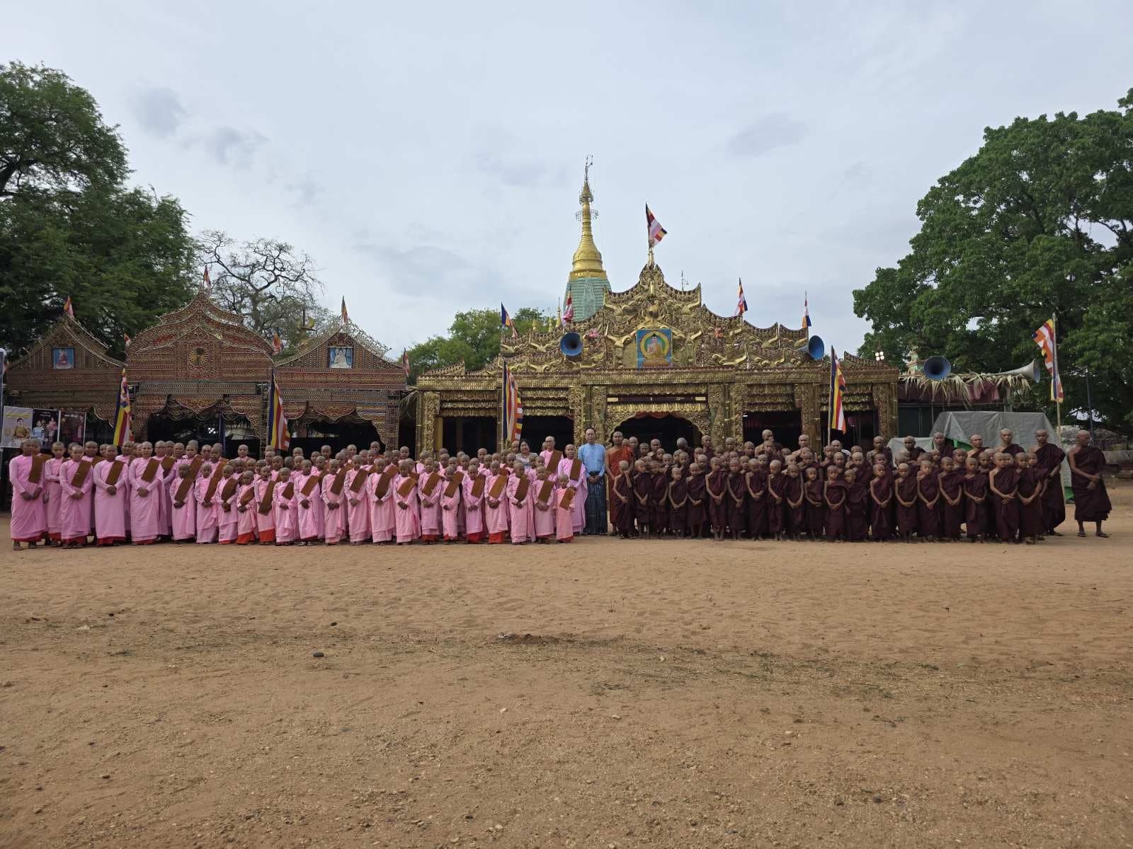 Hundreds of monks and nuns gathered in front of a gold-leaf temple at the Sein Wut Hmon family donation ceremony.